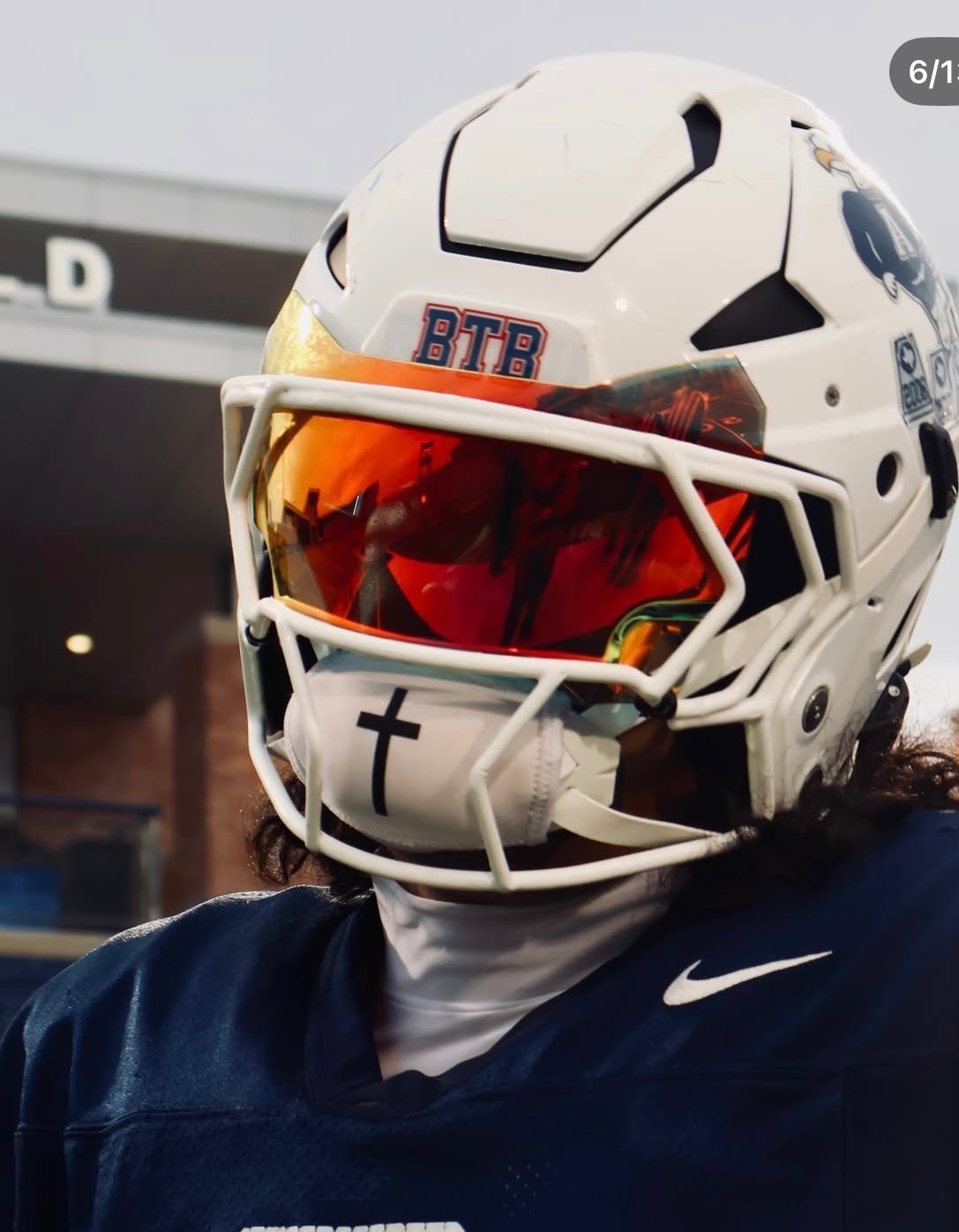 White football helmet with red visor and BTB logo worn by player in navy Nike jersey